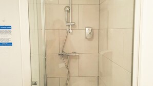 Eine Duschkabine mit Handbrause und Wandarmatur.