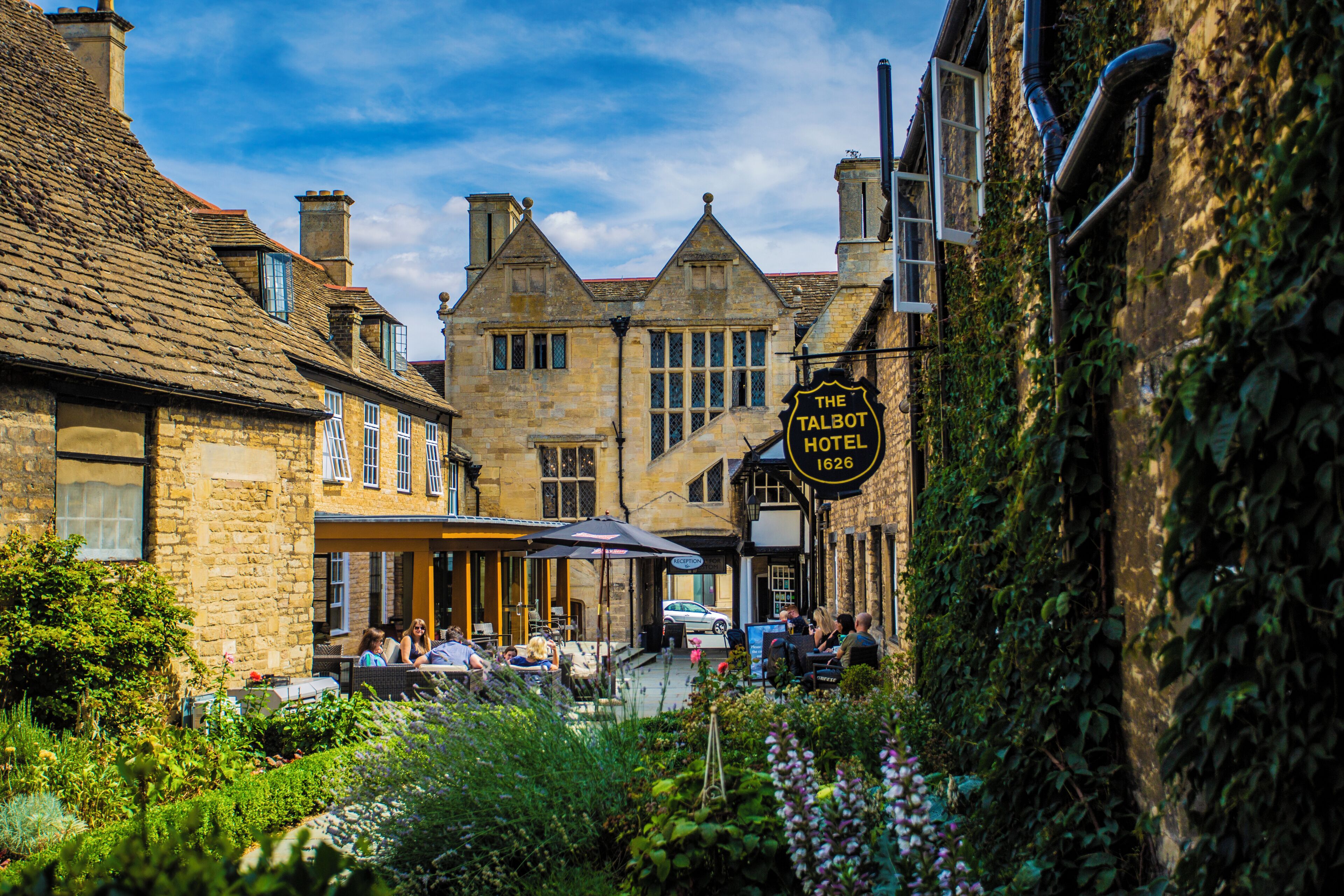 A historic stone building with a sign for 'The Talbot Hotel' dating back to 1626.