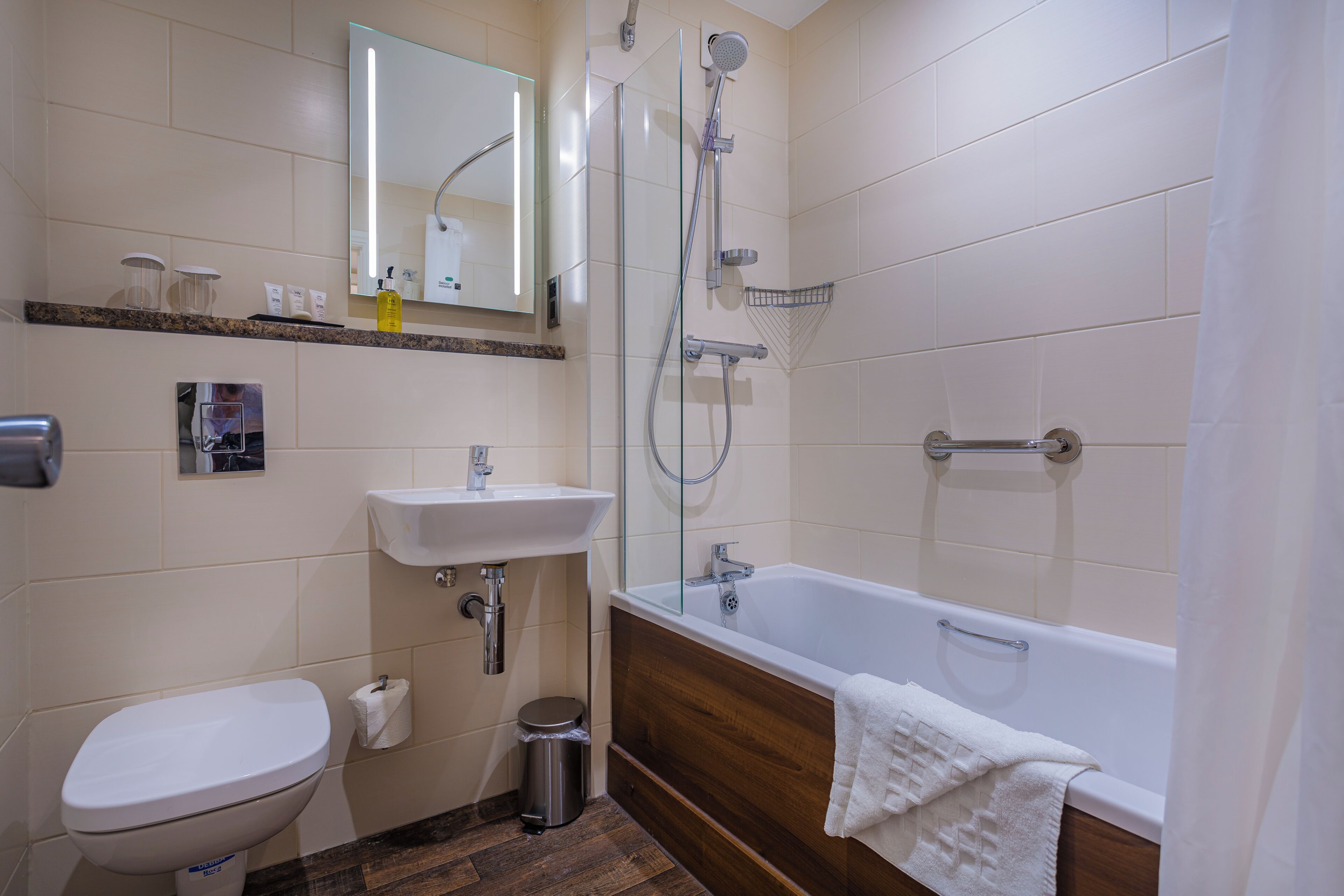 A bathroom with a toilet, sink, shower, and bathtub.