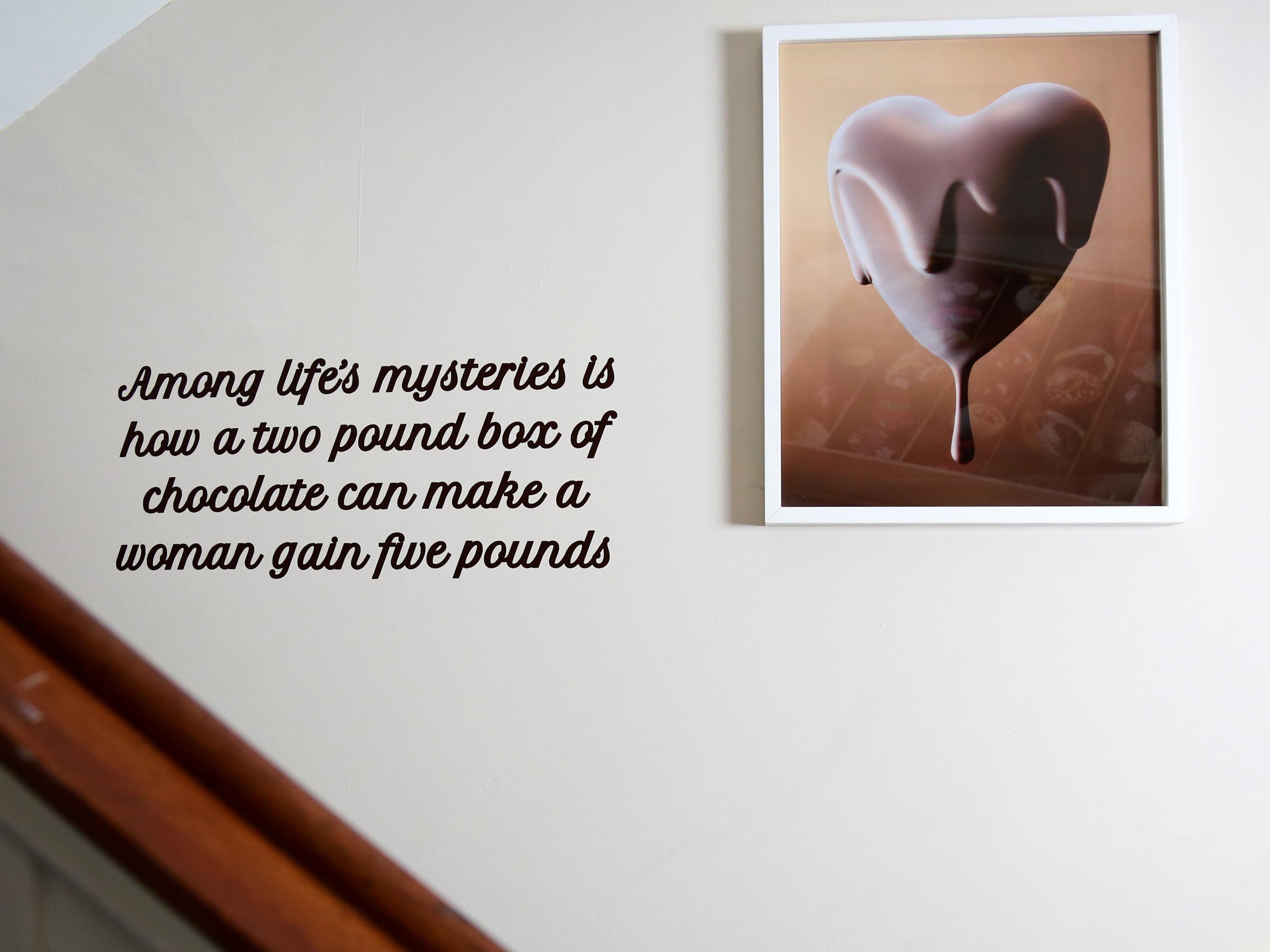 A framed picture of a chocolate heart on a wall.