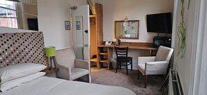 A hotel room with a bed, two chairs, a desk, a mirror, a television, and a window. - The Edward Hotel (Gloucester)
