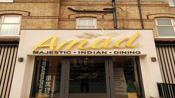 A building with a sign that reads 'Amad Majestic Indian Dining' and a website address.