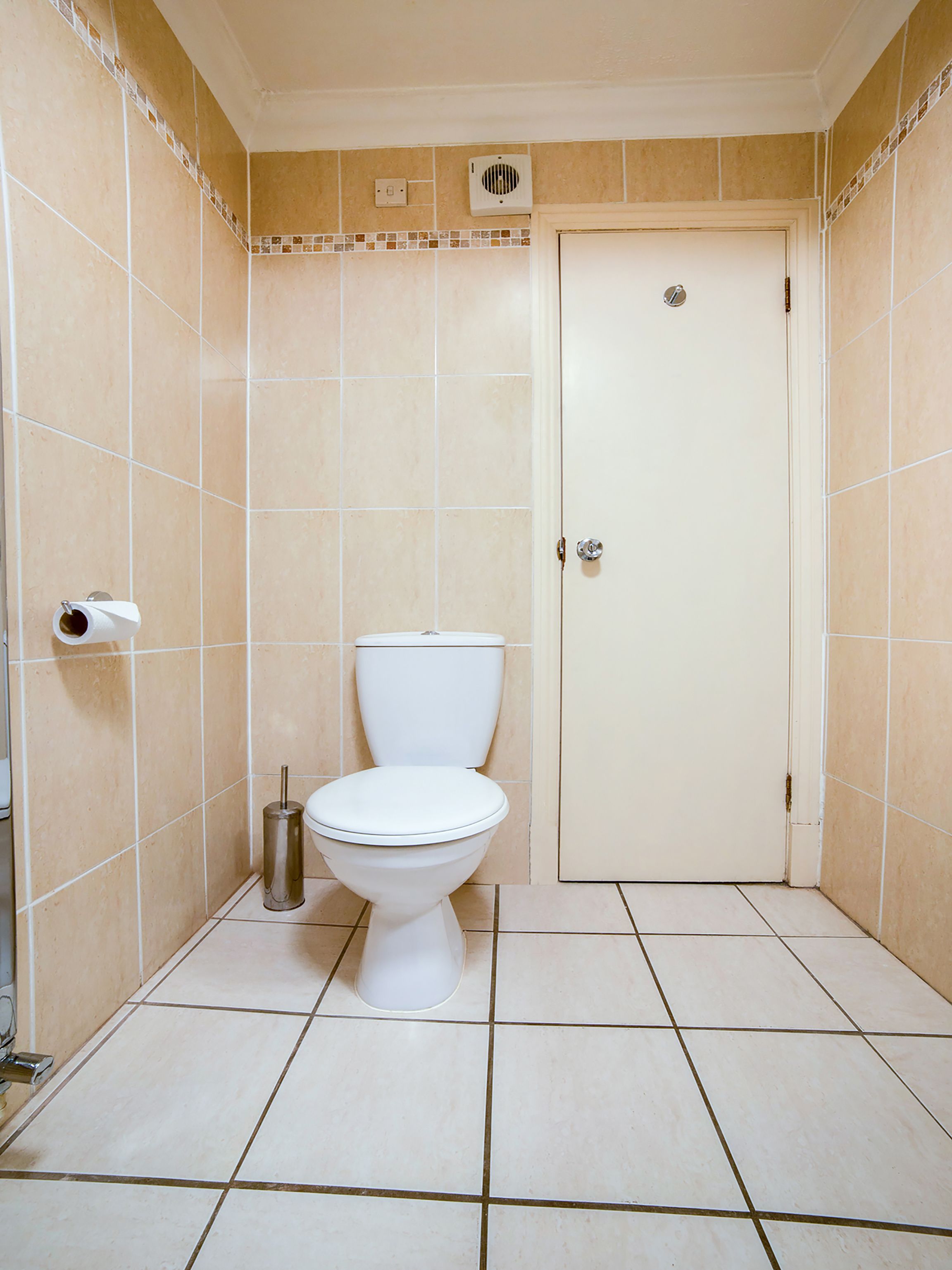 Ein Badezimmer mit Toilette, Handtrockner und Mülleimer.