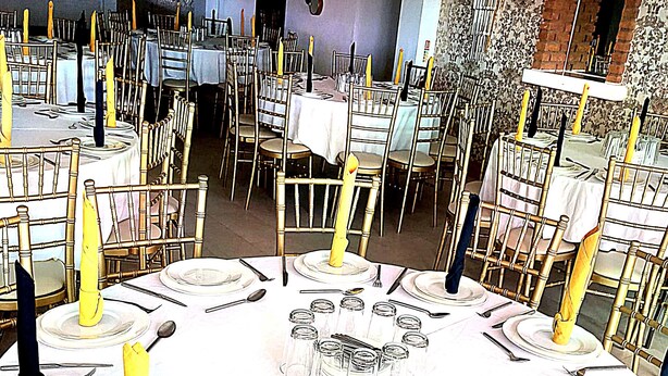 A banquet hall with round tables set for a formal event, featuring white tablecloths, gold chairs, and candles. - The Continental Hotel, Derby (Derby)