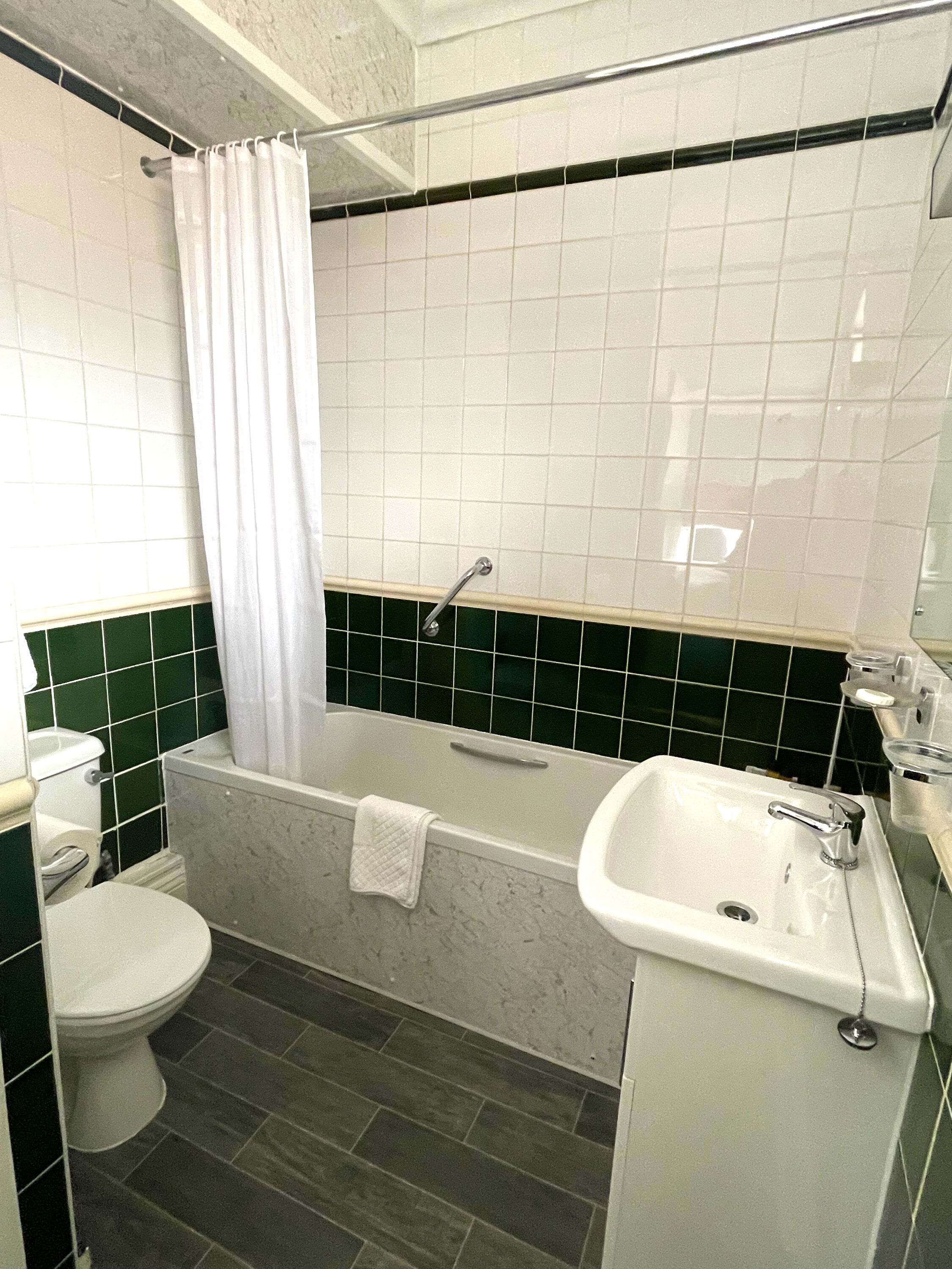 Une salle de bain avec une baignoire, des toilettes et un lavabo.