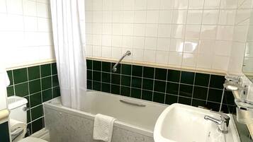 Une salle de bain avec une baignoire, des toilettes et un lavabo.