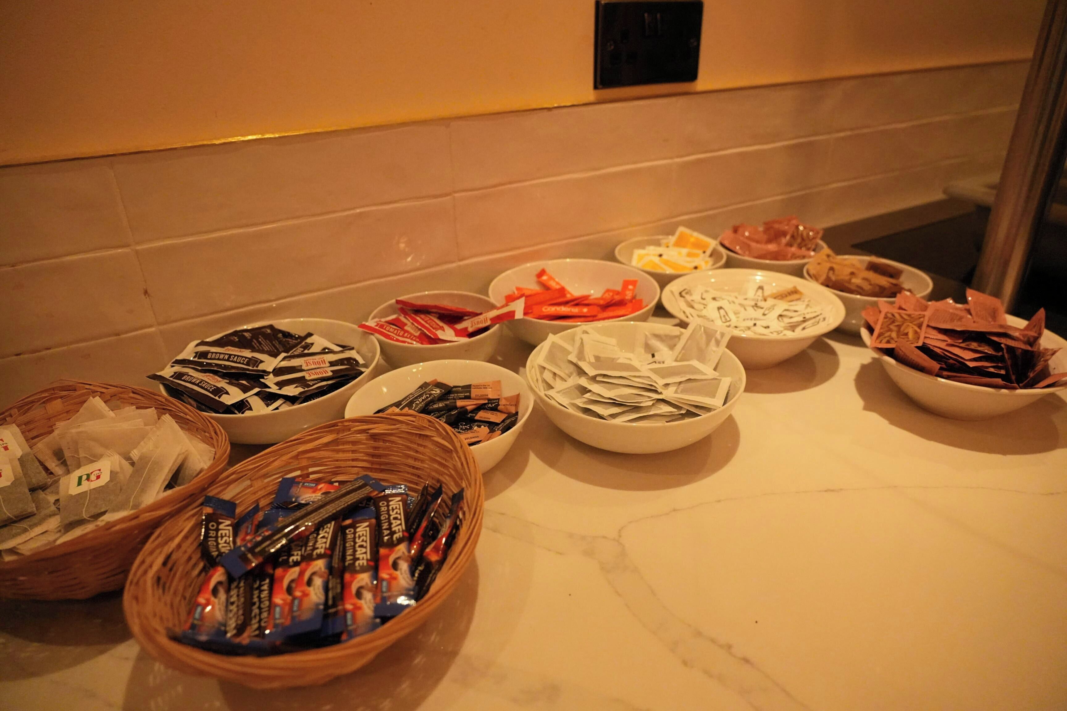 A buffet table with various food items and packaged goods.
