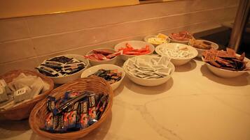 A buffet table with various food items and packaged goods.