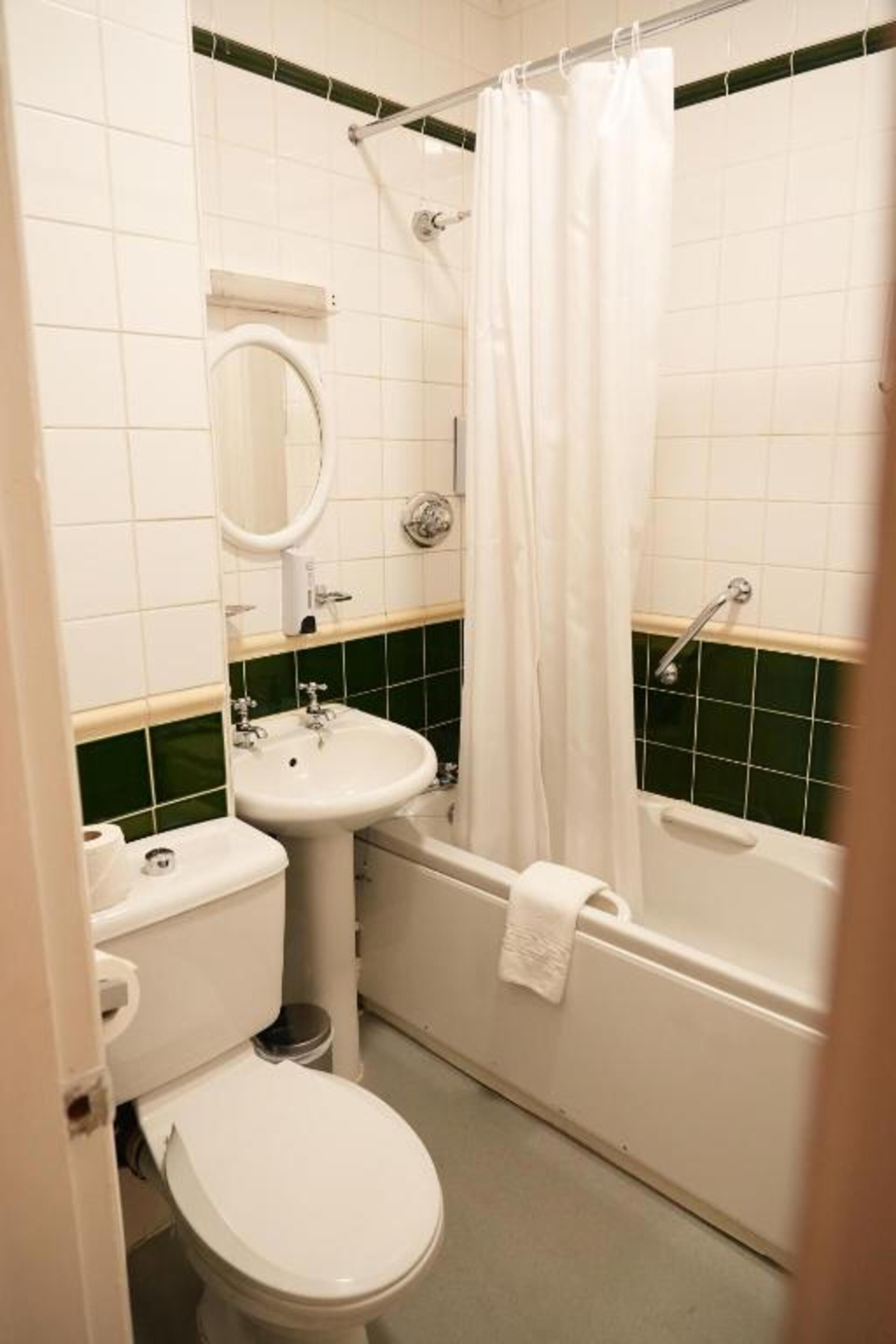 A bathroom with a toilet, sink, and bathtub.