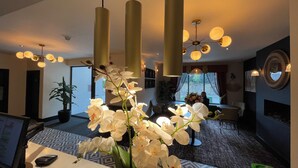 A hotel lobby with a reception desk, a large potted plant, and a seating area with a view of the outdoors. - The Continental Hotel, Derby (Derby)