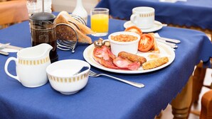 A breakfast setting with a coffee pot, tea pot, and a glass of orange juice on a table. - The Rosscourt - Adults only (Bournemouth)