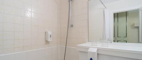 Une salle de bain équipée d’une douche, de toilettes, d’un lavabo et d’un miroir.