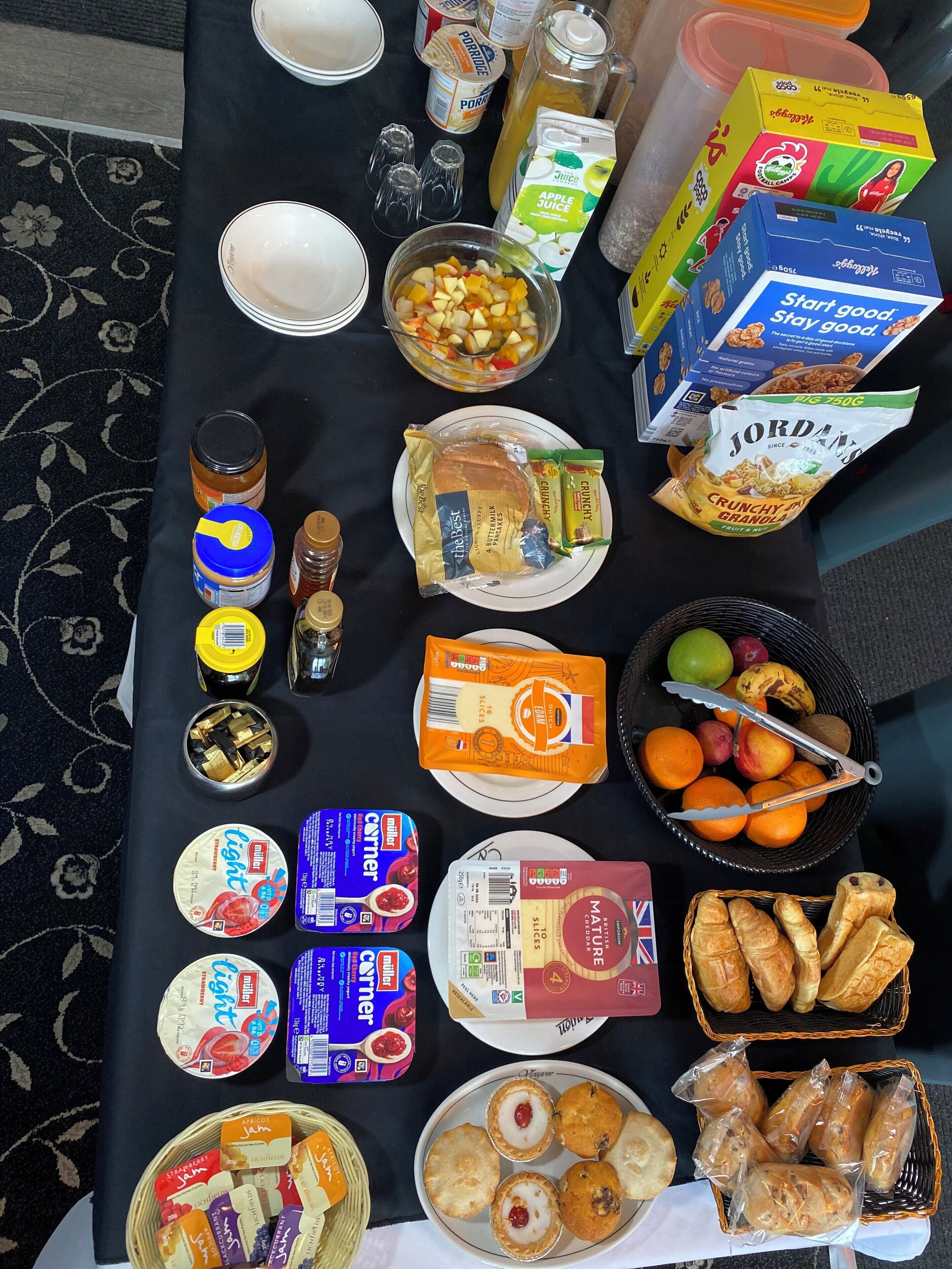 A table with various food items including fruits, bread, and condiments.