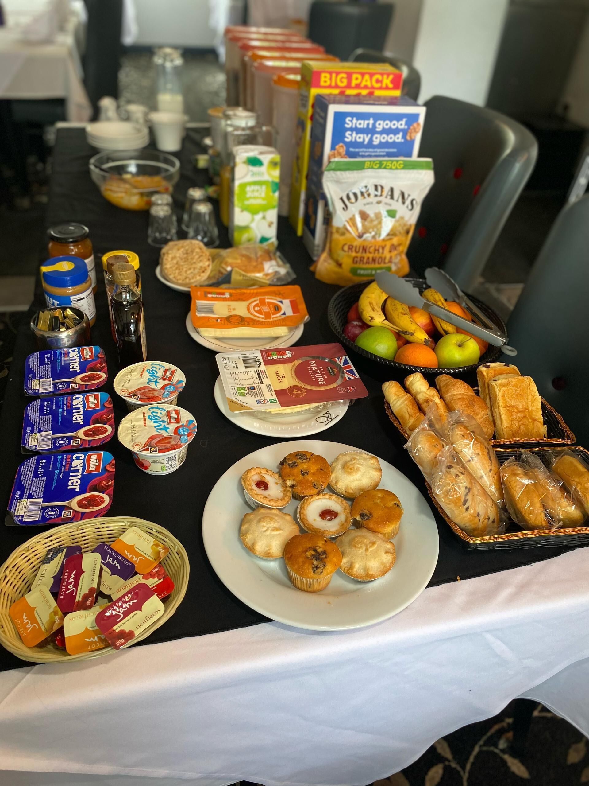 Une table où sont présentés divers aliments, notamment des pâtisseries, des fruits et des condiments.