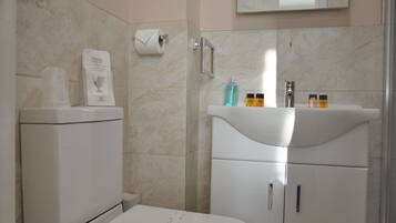 Un baño con inodoro, lavabo y espejo.