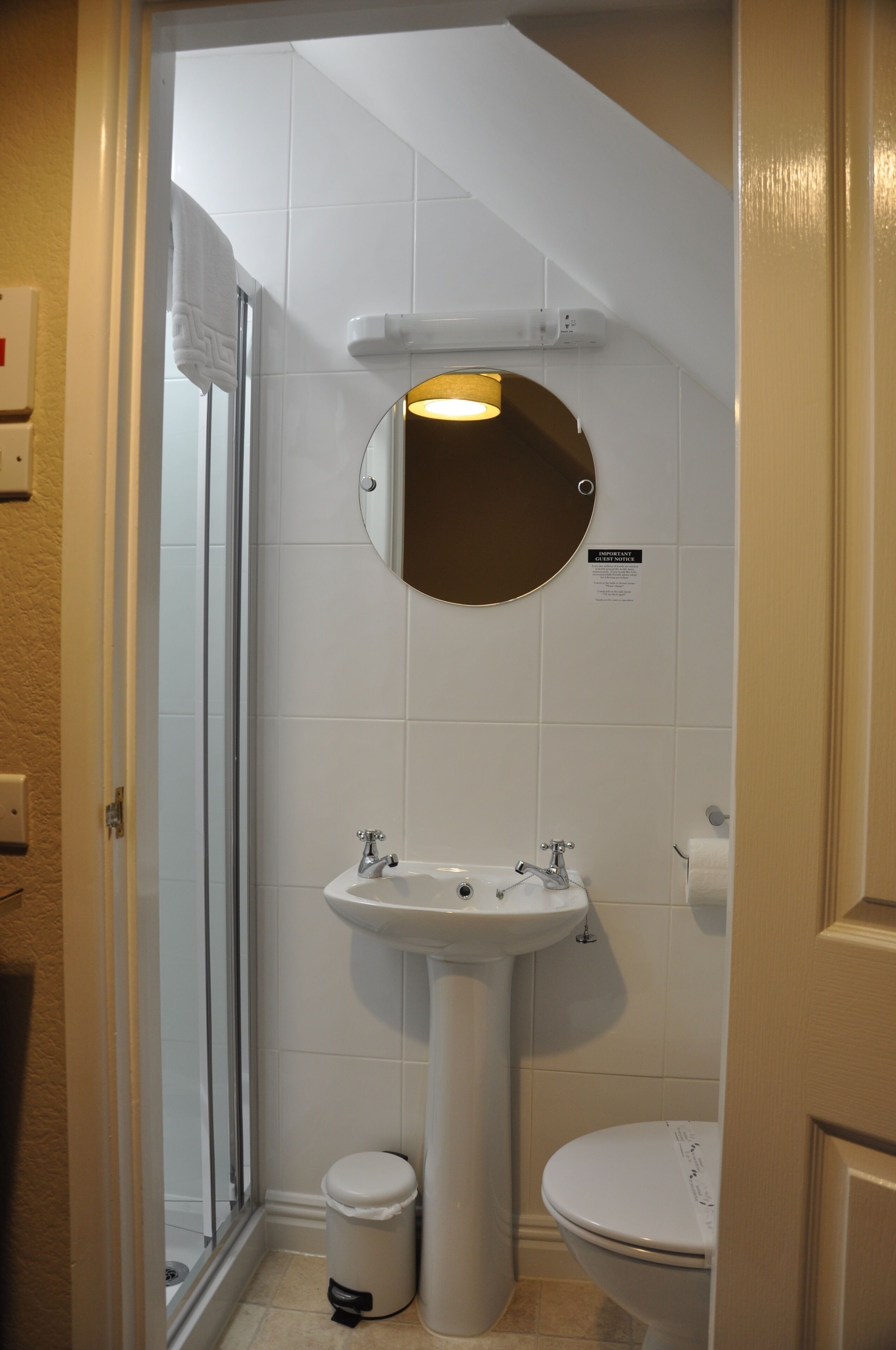 A bathroom with a sink, toilet, and a glass shower enclosure.