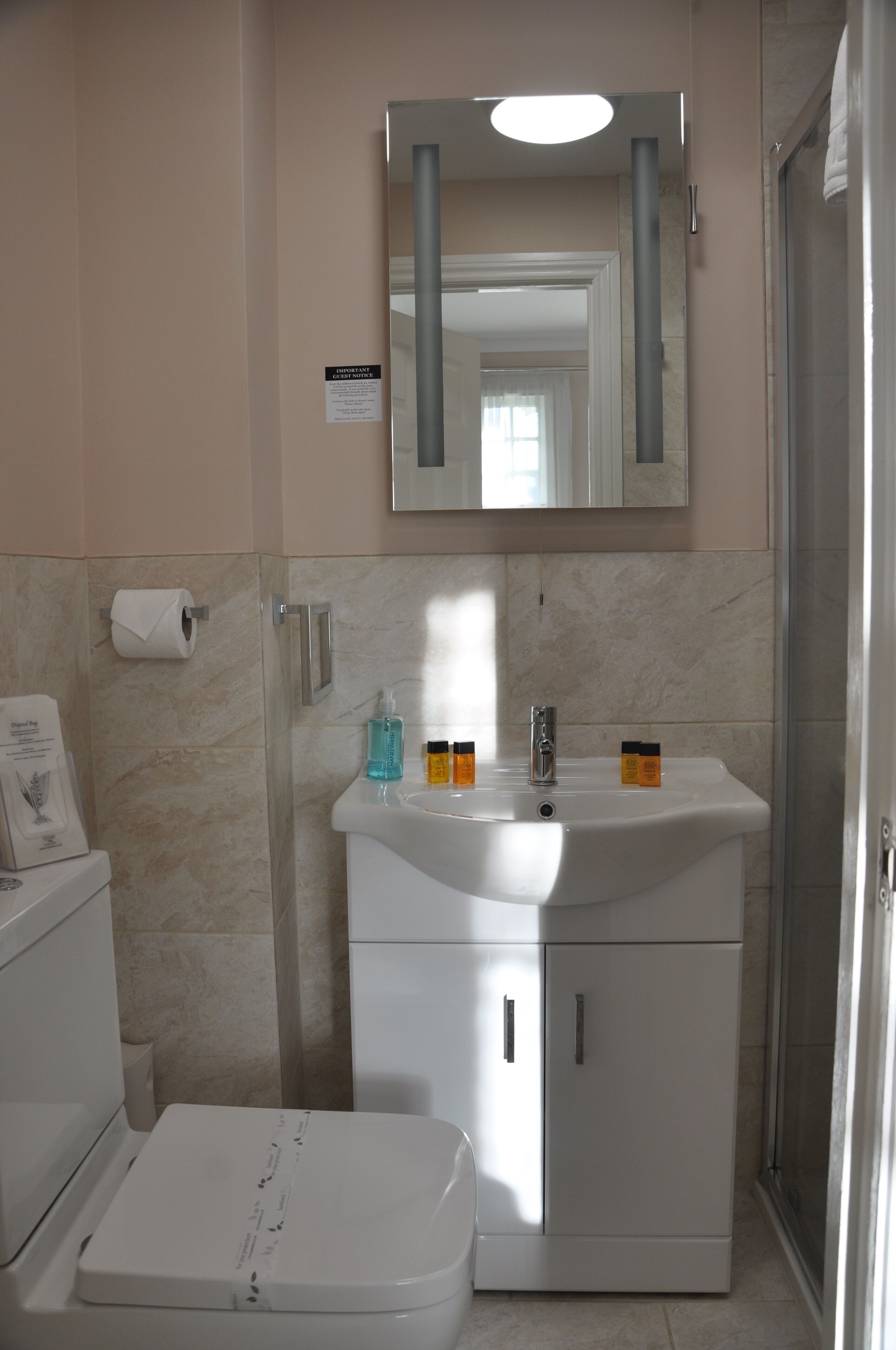 A bathroom with a toilet, sink, and shower.