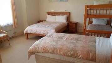 A bedroom with two single beds, a wooden chair, and a nightstand.