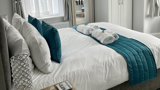 A neatly arranged bedroom with a bed, bedside table, and a wardrobe. - Bentley Lodge Guest House (Torquay)