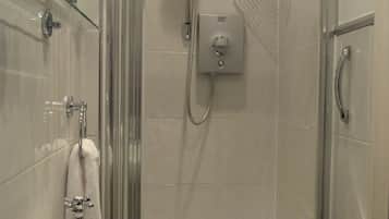 A modern bathroom with a glass shower enclosure, a white sink, and a handheld showerhead.
