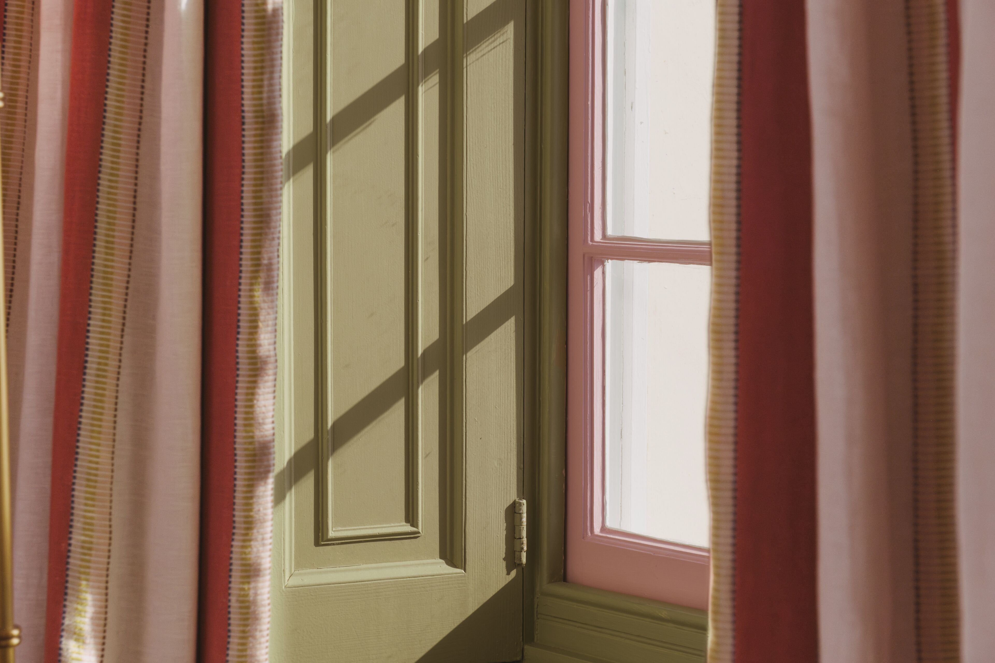 Una puerta con ventana, cortinas y un cierre.