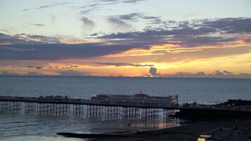 A pier extending into the water with a sunset in the background.