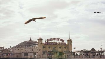 Un muelle con un edificio que lleva el rótulo "Brighton Pavilion Pier" al fondo.