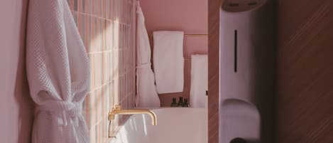 A bathroom with a white bathtub, a towel rack, and a showerhead.