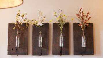 Cuatro jarrones fijados a la pared con diferentes flores.