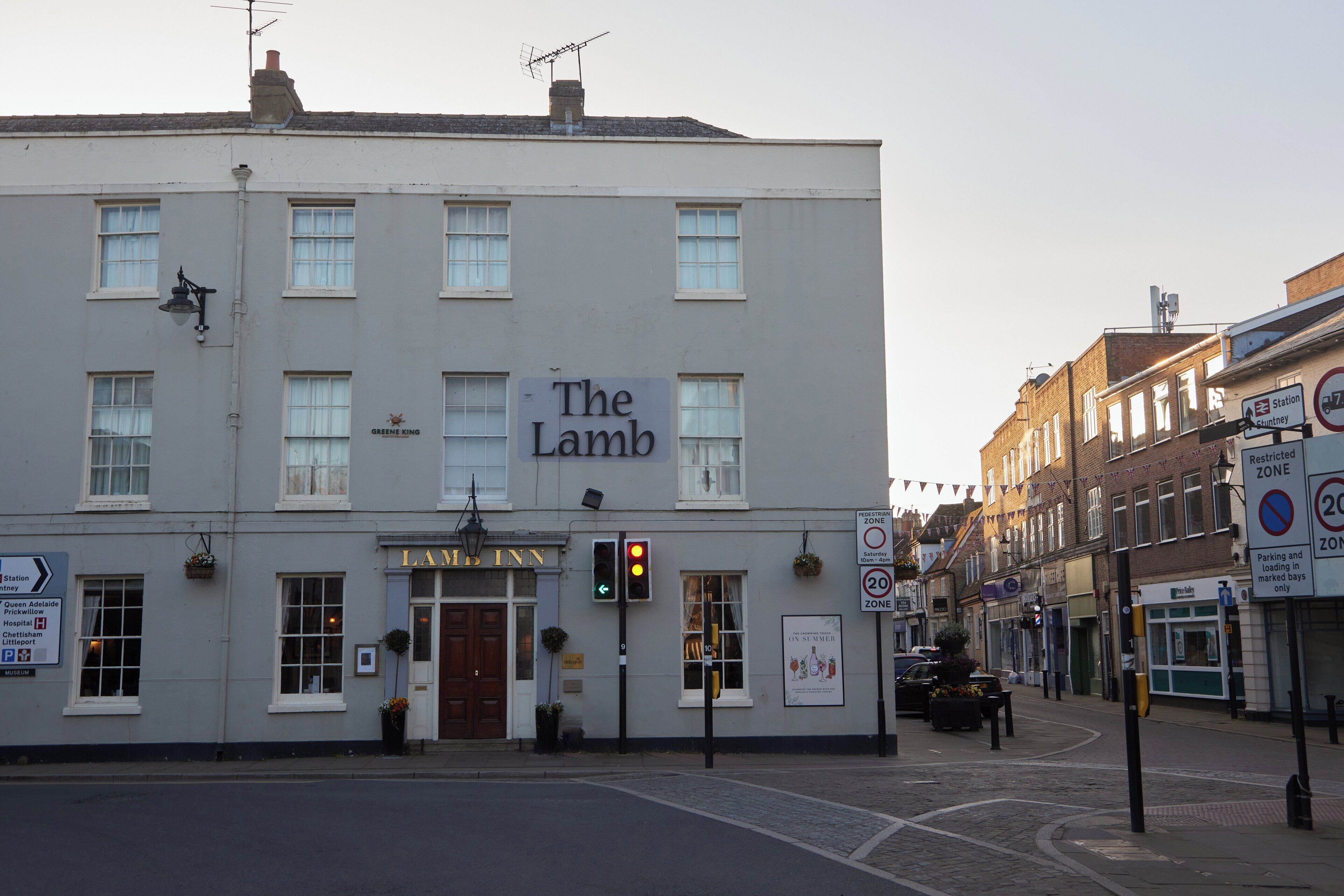 A building with a sign reading "The Lamb Inn" and a "Green King" sign above the entrance.