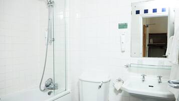 Un bagno con cabina doccia in vetro, un water bianco e un lavandino con uno specchio sopra.