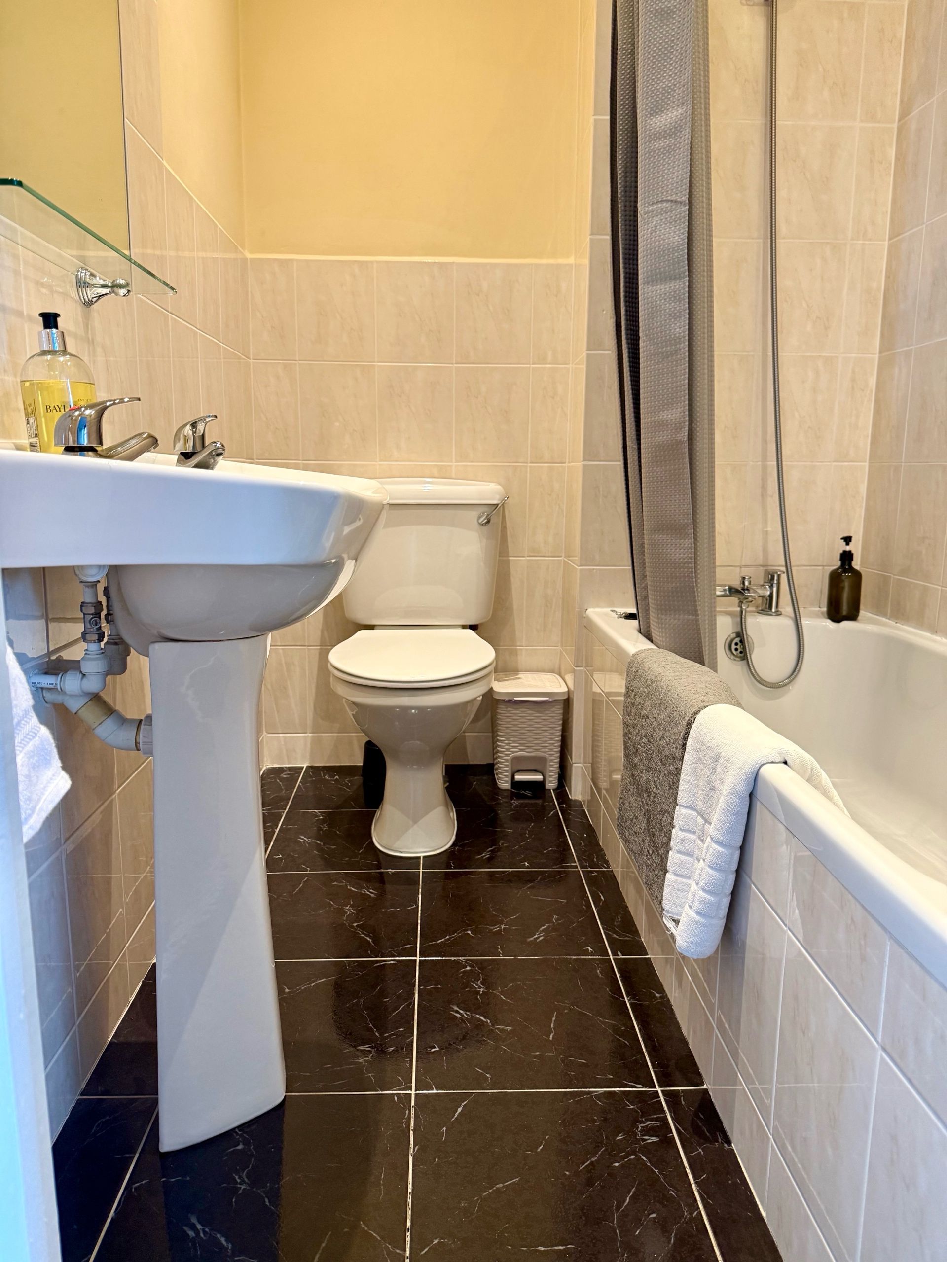 A bathroom with a white sink, toilet, and bathtub.