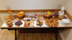 Een buffet met diverse gebakjes, fruit en patisserie.