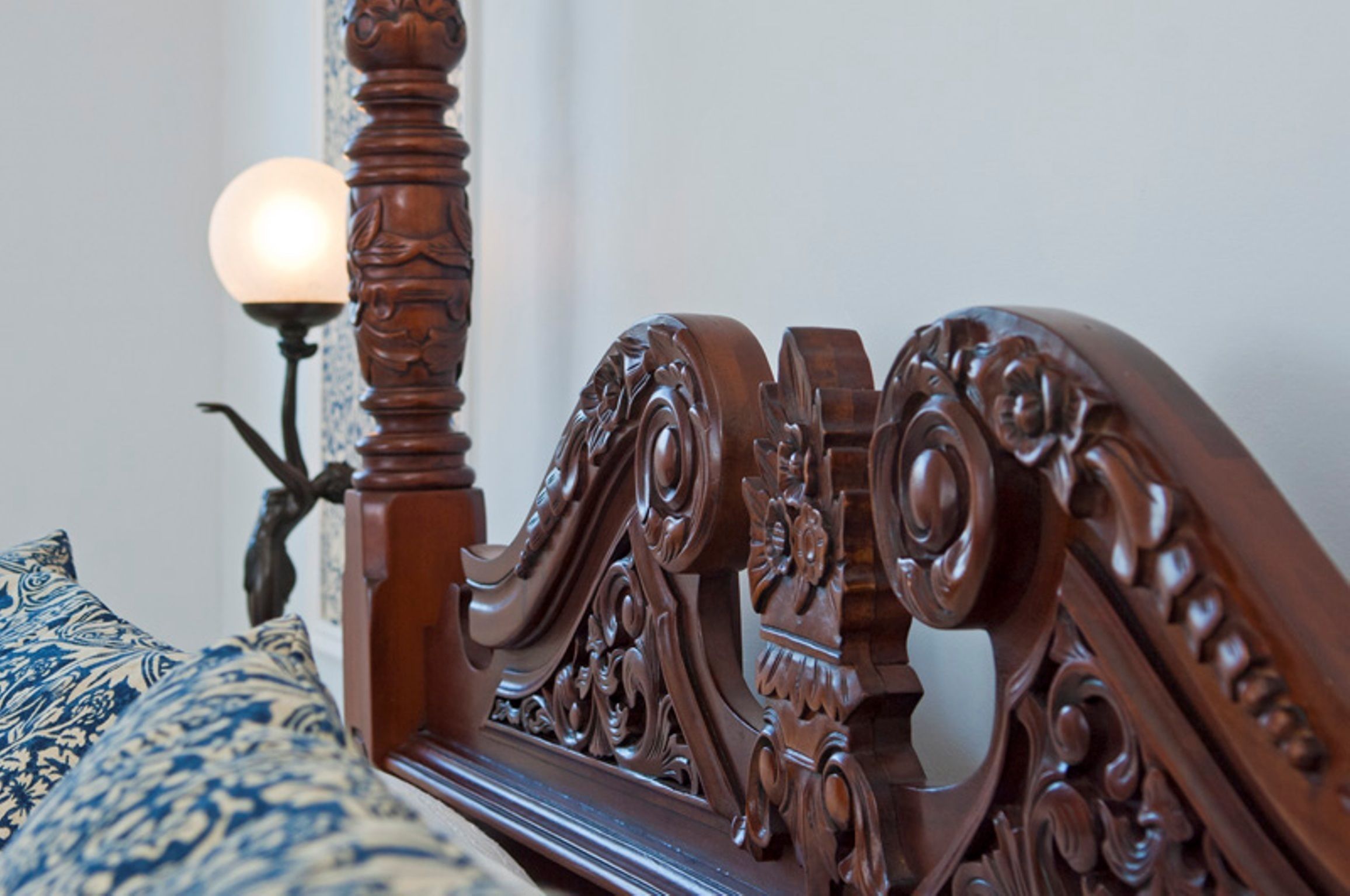 Uma estrutura de cama de madeira com entalhes detalhados e cabeceira combinando.