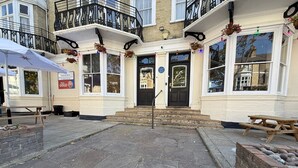 A building with a black door, a sign for 'GOGO', and a bench outside. - The Embassy Hotel (Great Yarmouth)