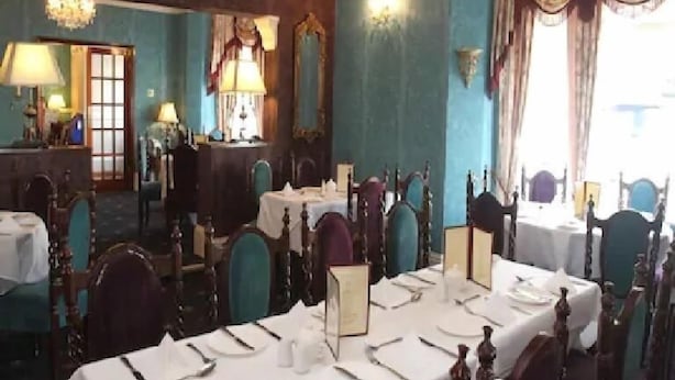 A formal dining room with multiple tables set for service, elegant chairs, and classic chandeliers. - The Embassy Hotel (Great Yarmouth)