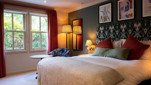 A well-lit bedroom with a large bed, two bedside lamps, a small round table, and a chair. - The Dukes Head Hotel (Wallington)