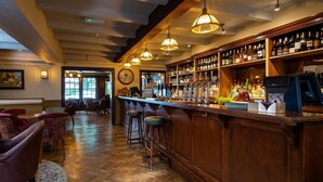 A bar area with wooden flooring, bar stools, and a variety of liquor bottles. - The Dukes Head Hotel (Wallington)