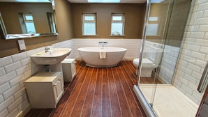 A modern bathroom with a freestanding bathtub, a sink, and a toilet.