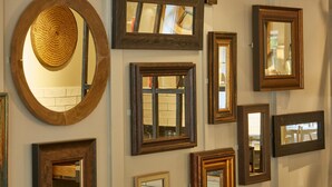 A wall with various framed mirrors and a circular mirror. - Dartbridge Inn Buckfastleigh by Greene King Inns (Buckfastleigh)