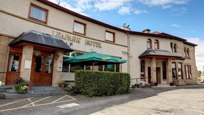 L'esterno dell'Hotel Leamark, con ingresso coperto, area parcheggio e siepe curata.