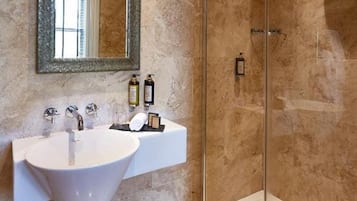 A bathroom with a white sink, a large mirror, and a glass-enclosed shower.