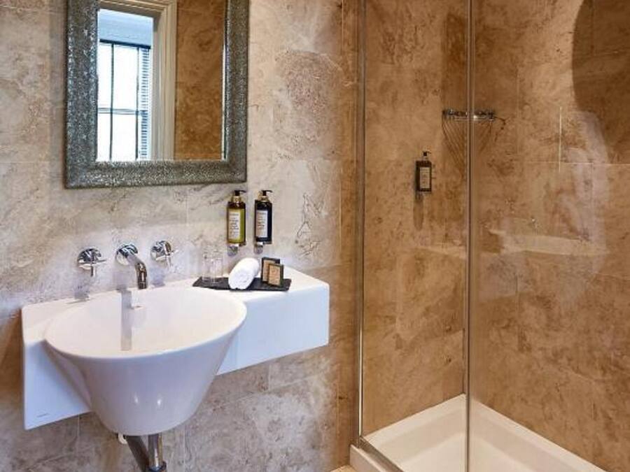 A bathroom with a white sink, a large mirror, and a glass-enclosed shower.