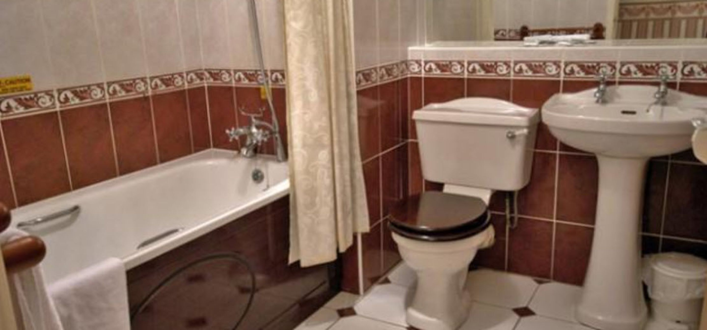 A bathroom with a bathtub, toilet, and sink.
