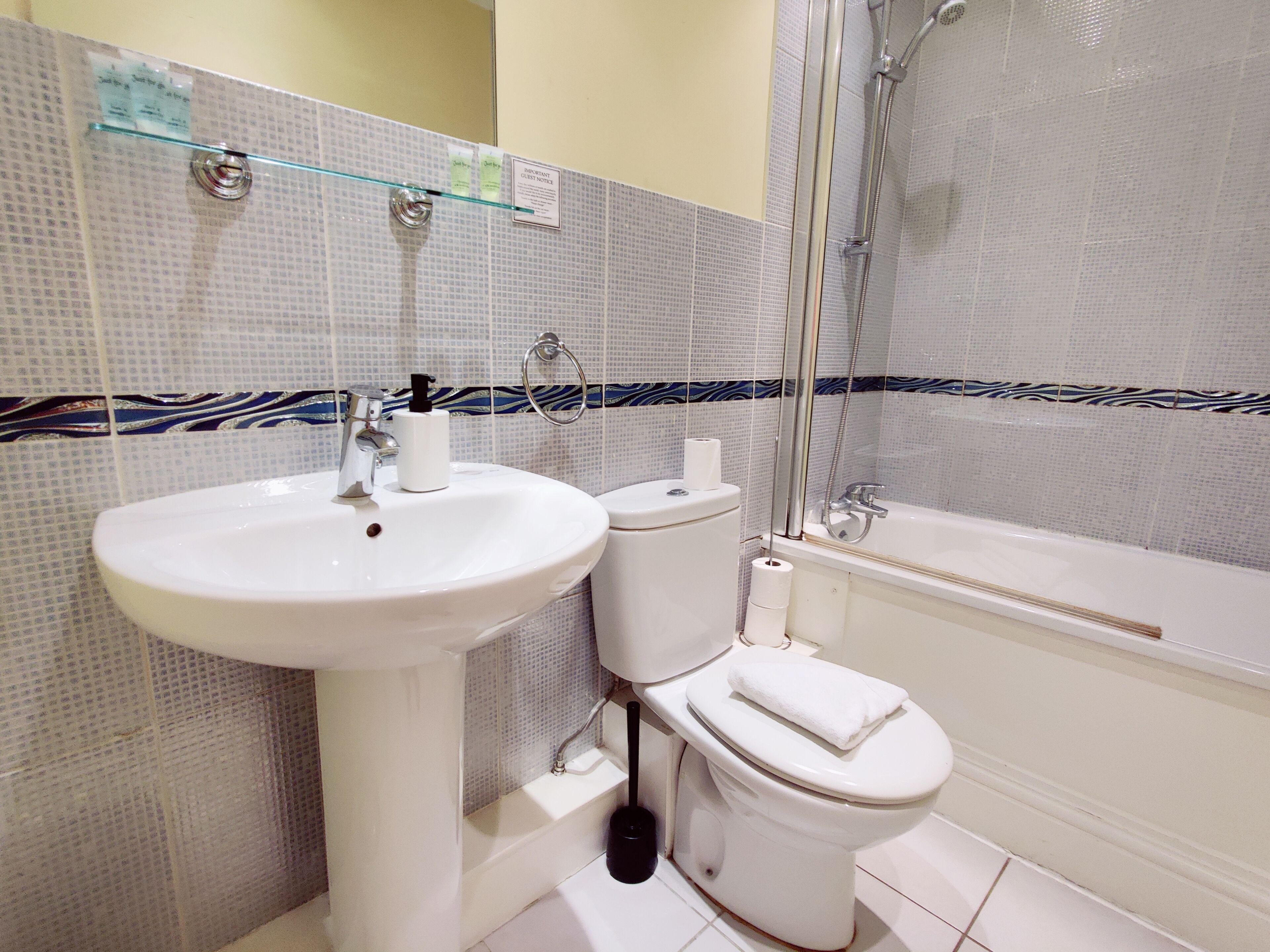 Un baño con lavamanos, inodoro y bañera.