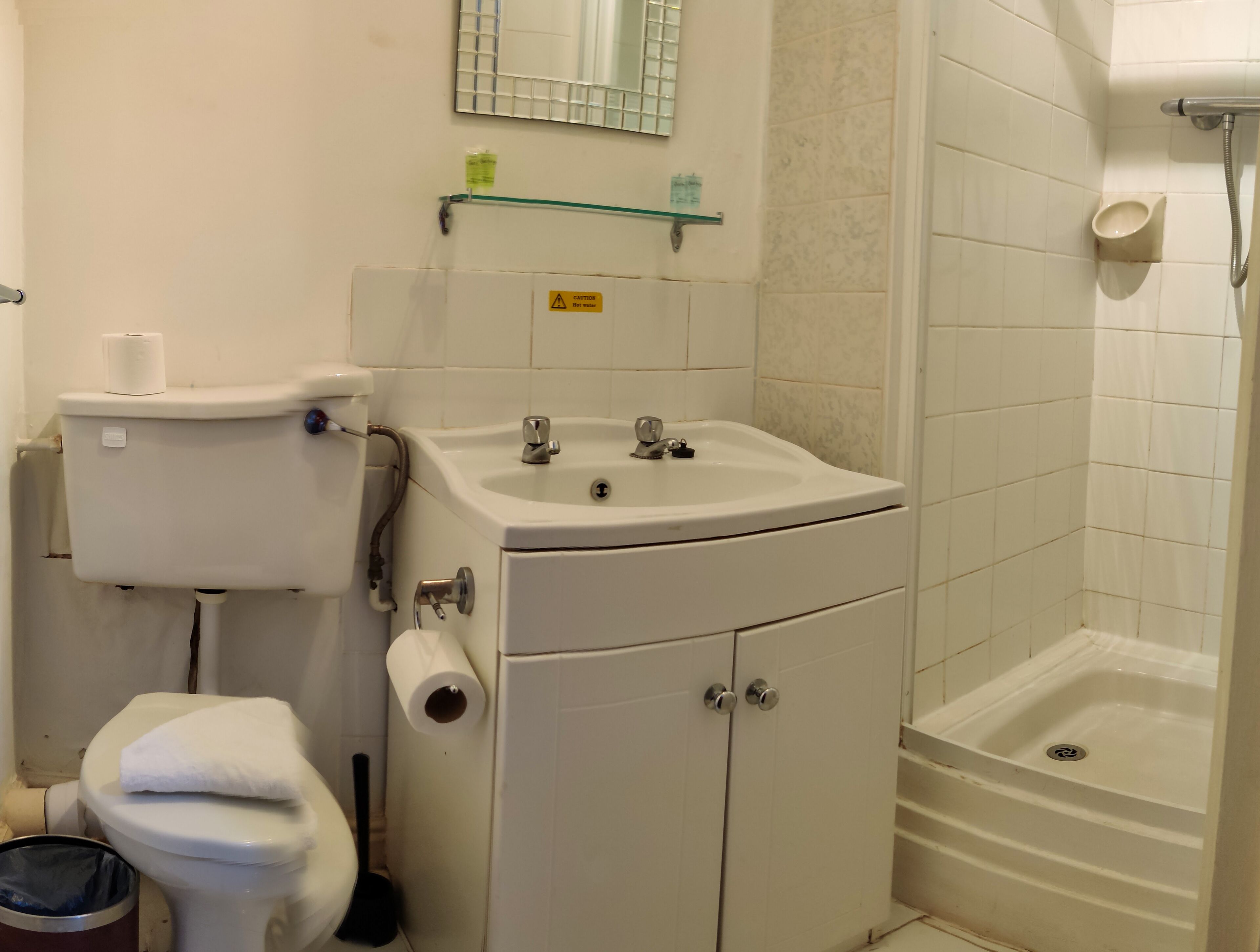 Egy fürdőszoba, amelyben WC, mosdókagyló és zuhanyzó található.