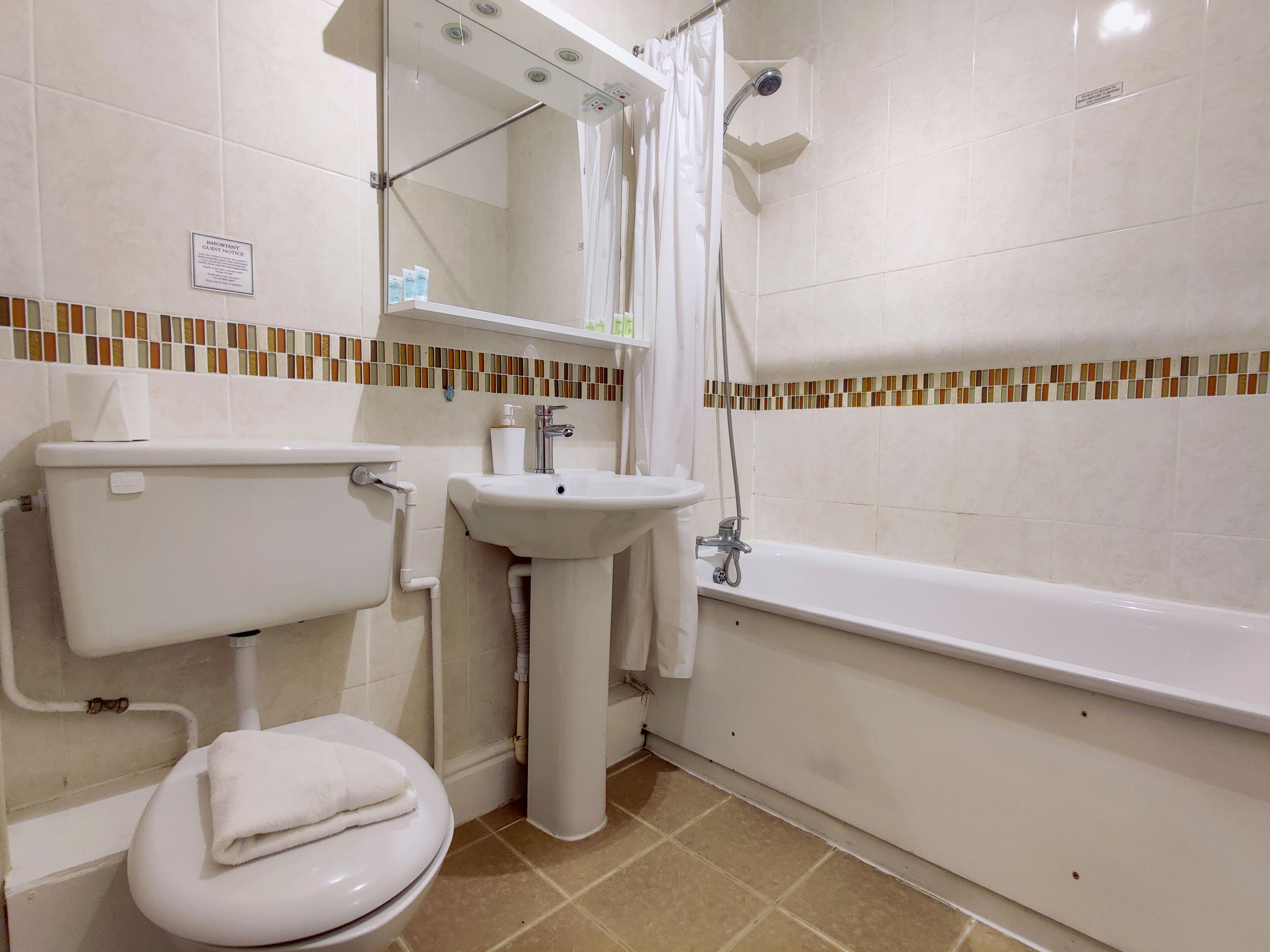 Un baño con inodoro, lavamanos y bañera.