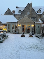 A stone building with a snow-covered roof and a welcoming entrance.