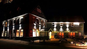 A traditional building with a sign reading "SHURLAND" and a well-lit outdoor seating area. - Shurland Hotel (Sheerness)
