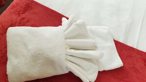 Une serviette blanche avec un nœud posée sur un coussin rouge.